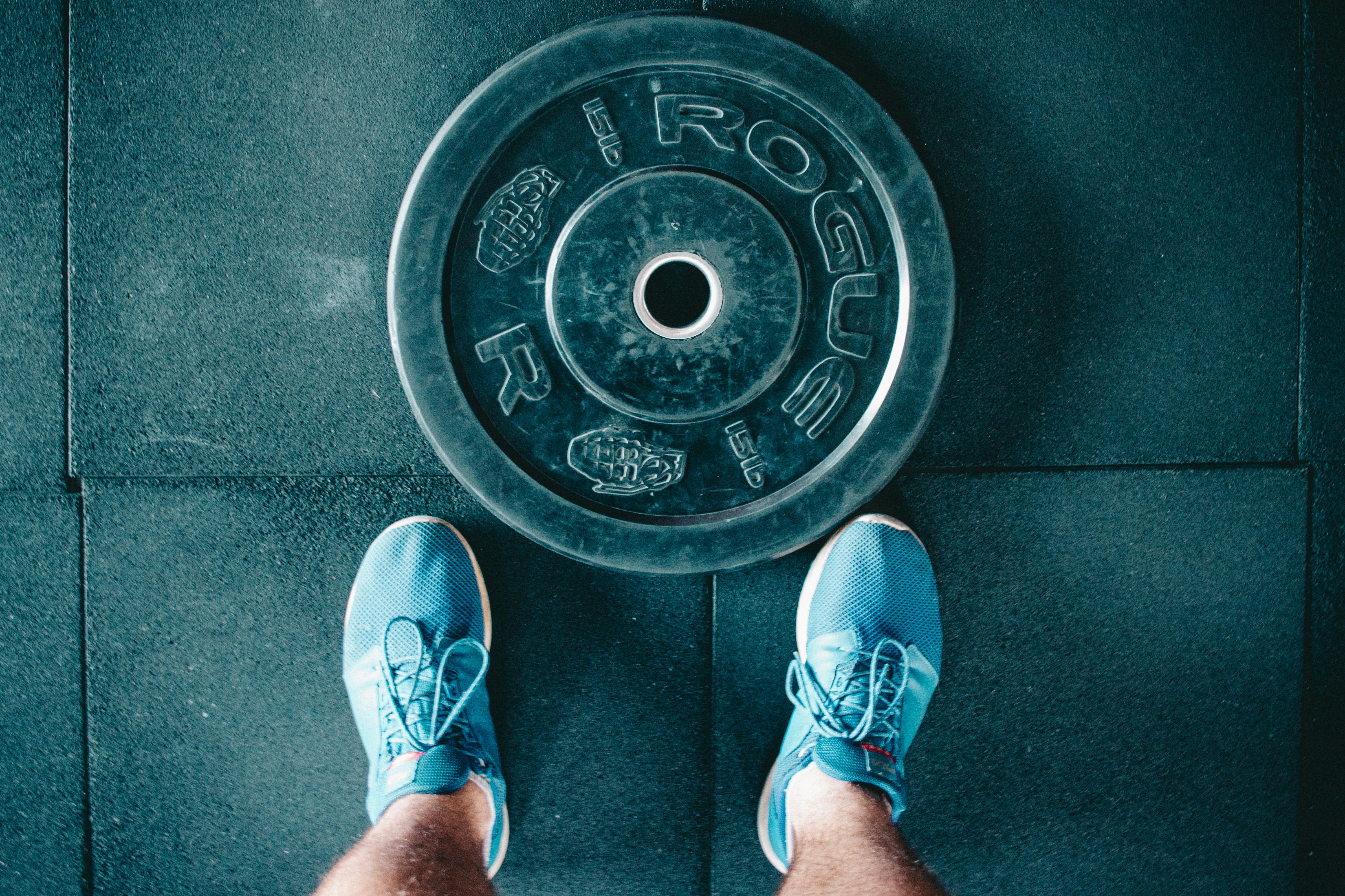 person standing beside black weights