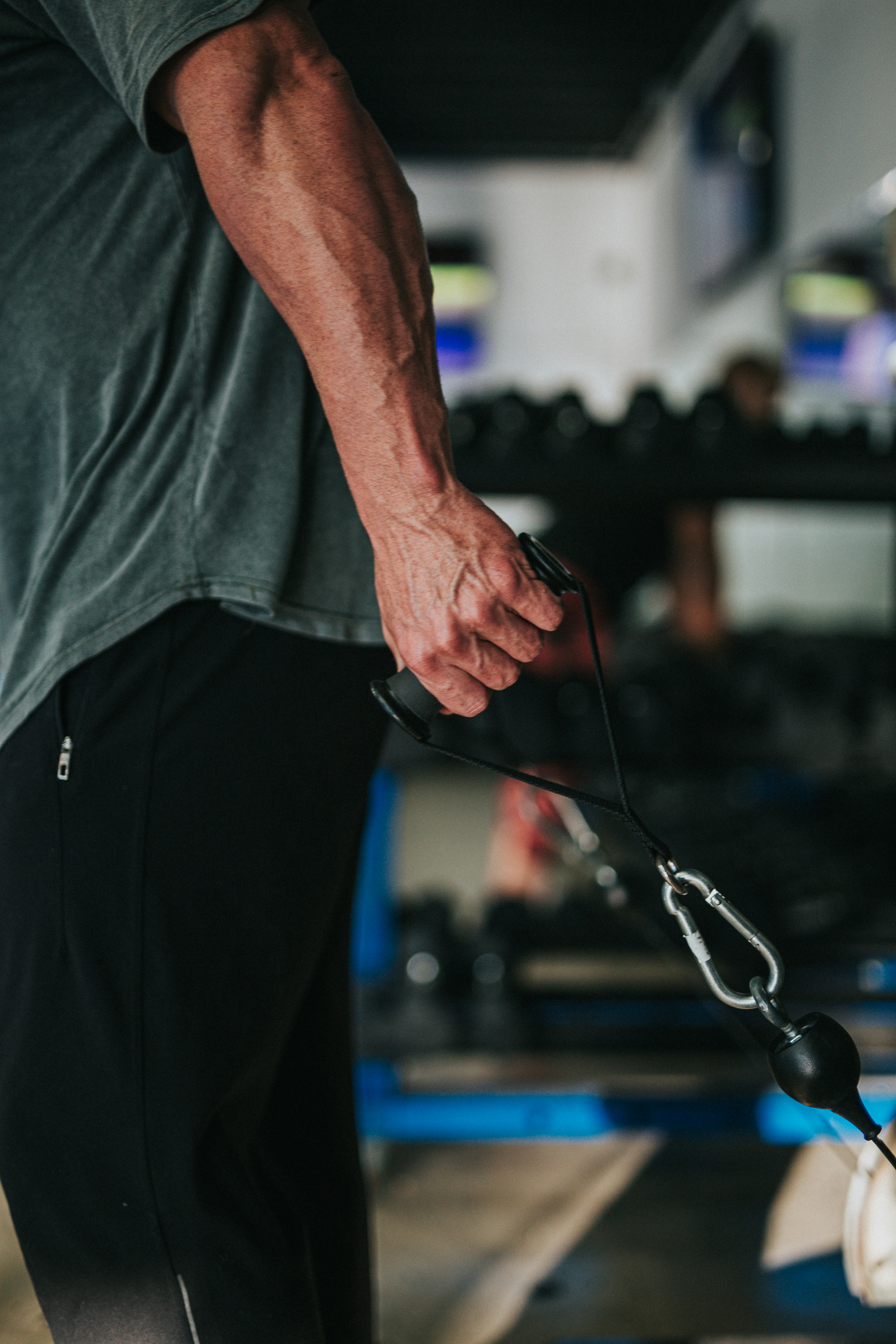 man in gray t-shirt and black pants holding black corded headphones