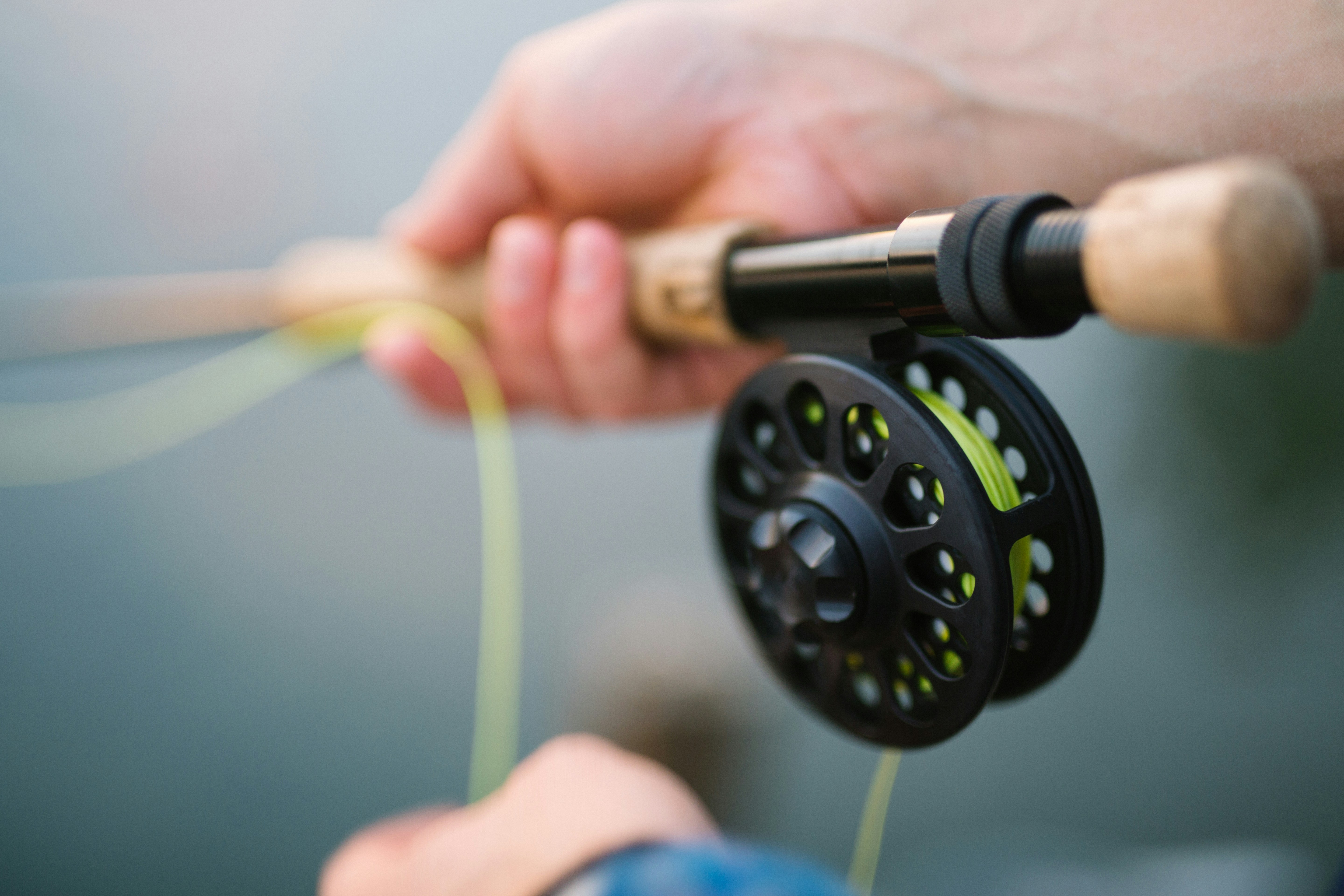 person holding black and brown fishing rod